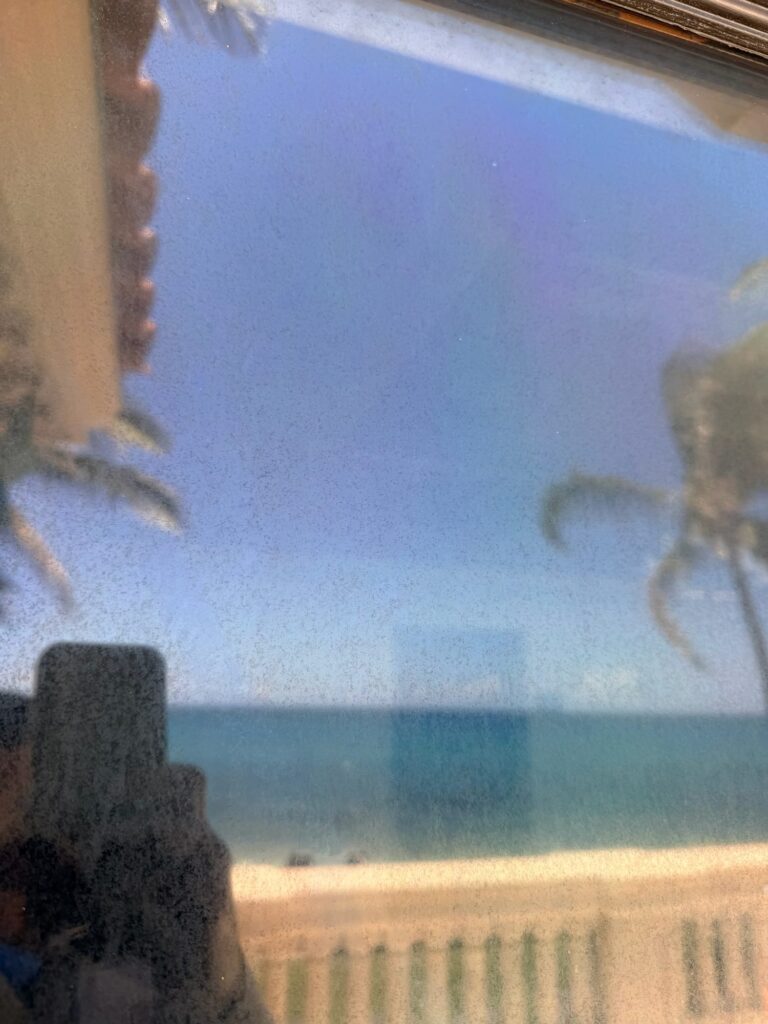 Hazy window glass with the ocean behind it before restoration in Jupiter, FL